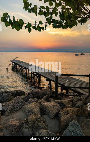 Seeblick bei Sonnenuntergang vom Fußweg in Cisano, Bardolino, Gardasee, Italien Stockfoto