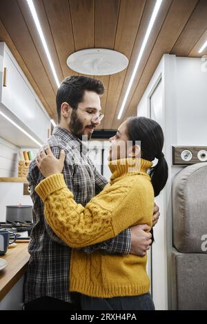 Vertikales Seitenbild des jungen Paares, das sich im Wohnwagen umgibt Stockfoto