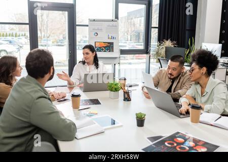 Teamleiter, der mit Geschäftsleuten aus verschiedenen Rassen spricht, während eines Meetings im modernen Büro, Vielfalt Stockfoto