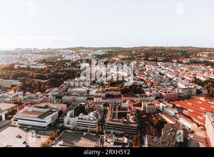 Horizontale Luftaufnahme von Straßen und Gebäuden Lissabons bei Sonnenuntergang. Lissabon mit historischem Stadtzentrum und Dächern von oben in der goldenen Stunde - aufgenommen Stockfoto