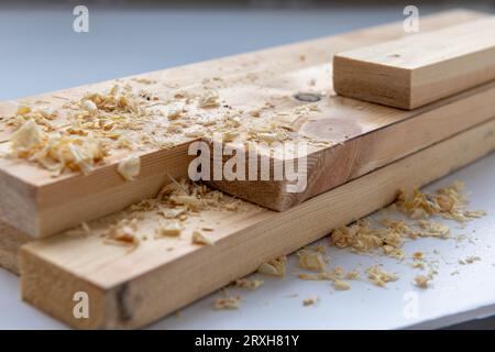 Nahaufnahme von vorbereitetem Kiefernholz mit einigen Holzspänen. Stockfoto