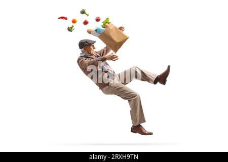 Älterer Mann mit einem Lebensmittelbeutel, der auf weißem Hintergrund umfällt und isoliert fällt Stockfoto