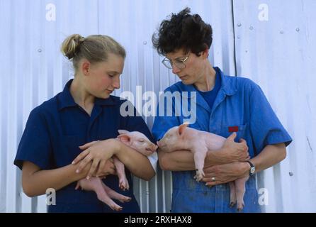 Die Frau und ihre Tochter halten Ferkel; Bennet, Nebraska, Vereinigte Staaten von Amerika Stockfoto