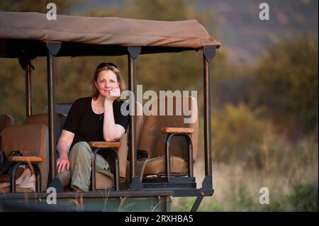 Frau genießt eine Safari-Tour im Madikwe Game Reserve in Südafrika; Südafrika Stockfoto