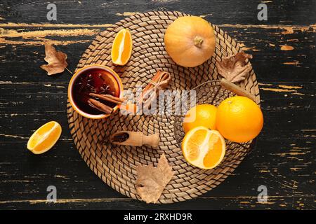 Tasse heißer Glühwein mit Orange und Zimt auf schwarzem hölzernem Hintergrund Stockfoto