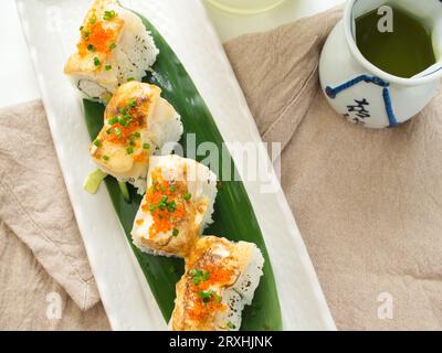 Blick von oben auf Sushi-Brötchen mit grünem Tee im japanischen Restaurant. Stockfoto