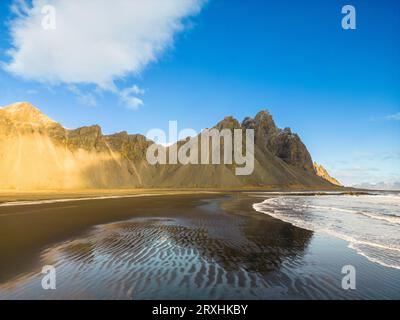 Blick aus der Vogelperspektive auf Stokksnes schwarzen Sandstrand mit massivem felsigem Bergkamm, Vestrahorn in island. Nordische Landschaft rund um isländische Natur mit atlantikküste, Winterwunderland. Stockfoto