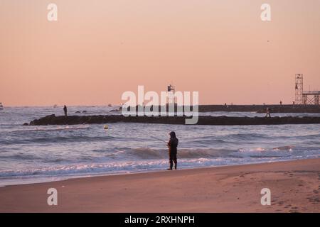 Fisherman Surf Casting am Strand in Avon by the Sea New Jersey an der Küste von New Jersey bei Sonnenaufgang Stockfoto