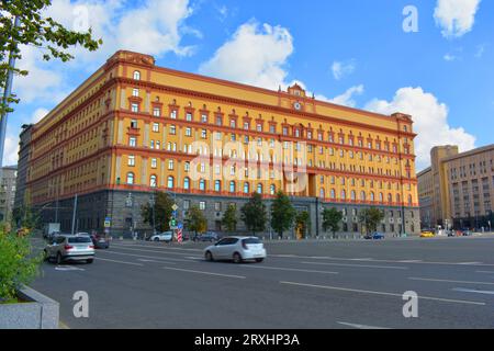 Das Gebäude ist gelb-rot, mit einer Straße vorne und einem blauen Himmel hinten Stockfoto