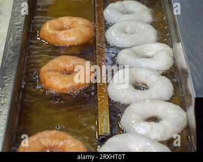 Kochen der frittierten süßen leckeren Donuts in Fritteuse heißes Öl Stockfoto