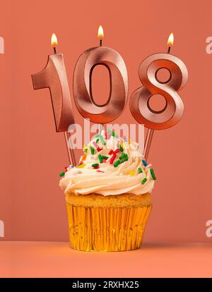 Kerze Nummer 108 - Kuchen Geburtstag im Korallenfusionshintergrund Stockfoto