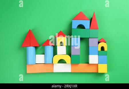 Wunderschönes Schloss mit bunten Blöcken auf grünem Hintergrund, flache Lage. Kinderspielzeug Stockfoto