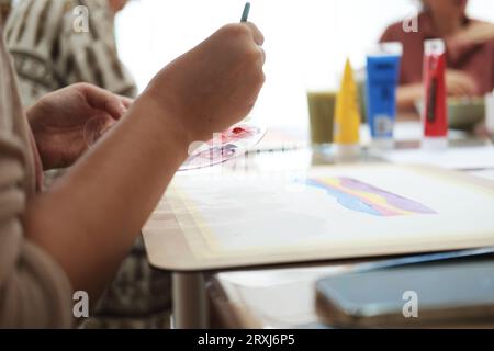 Nahaufnahme der Hand einer jungen Frau, die einen Pinsel zum Malen hält Stockfoto