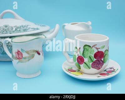 Vintage-Set aus Tassen isoliert auf blauem Hintergrund. Antike Teetasse im asiatischen Stil mit Blumenmuster Stockfoto