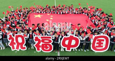HUAI'AN, CHINA = 26. SEPTEMBER 2023 – Grundschüler halten Warnsignale zum Nationalfeiertag in Huai'an, Provinz Jiangsu, China, September Stockfoto