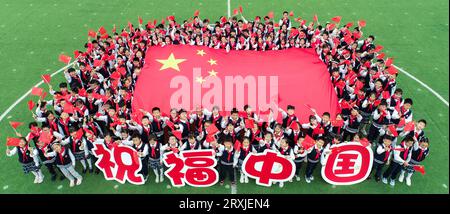 HUAI'AN, CHINA = 26. SEPTEMBER 2023 – Grundschüler halten Warnsignale zum Nationalfeiertag in Huai'an, Provinz Jiangsu, China, September Stockfoto