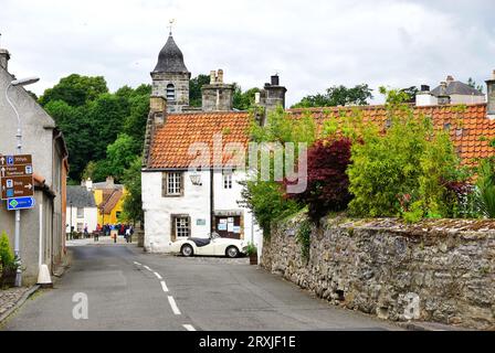 Ein klassischer Sportwagen, der neben einem Gebäude aus weißem Stein mit rotem Ziegeldach auf einer schmalen Straße im historischen Dorf Culross in Fife, Schottland, geparkt ist Stockfoto