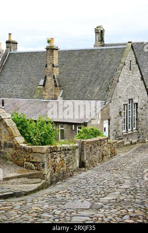 Historisches Steinhaus an einer rauen Kopfsteinpflasterstraße im Dorf Culross, Fife, Schottland. Viele der restaurierten Häuser sind als Wohnhäuser vermietet Stockfoto