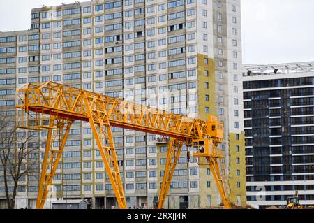 Hochschwere, gelbe Metalleisentragkonstruktion stationäre industrielle leistungsfähige Portalkran mit Brückenform auf Stützen zum Heben von Fracht auf einem m. Stockfoto