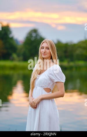 Porträt einer jungen Frau am Fluss bei Sonnenuntergang Stockfoto