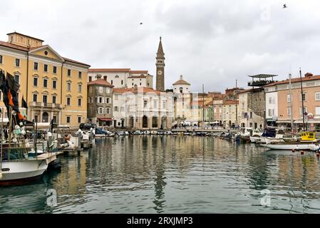 Bewölkter Morgen in Piran, Blick auf Tartini Trg und den Glockenturm der Chiesa madre di San Giorgio vom Hafen. März 2016, Piran, Istrien, Slowenien Stockfoto