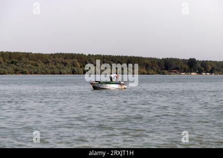 Serbien, 23. September 2023: Man angelt in einem Boot, das an der Donau ankert Stockfoto