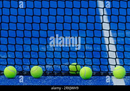 Drei Paddle-Tennisbälle in der Nähe des Netzes eines Paddle-Tennisplatzes Stockfoto