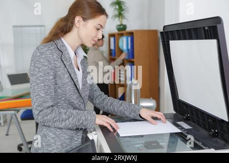 Die Lehrerin druckt Arbeitsblätter für ihre nächste Lektion aus Stockfoto