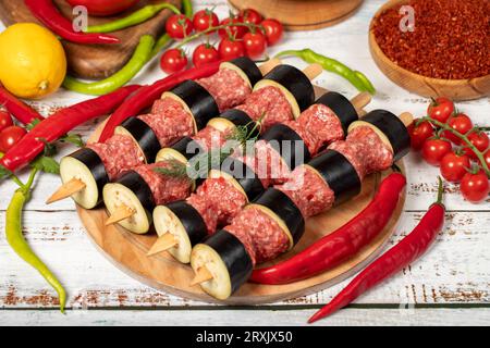 Auberginen-Kebab auf Holzhintergrund. Roher Schisch-Auberginen-Kebab mit Kräutern und Gewürzen Stockfoto