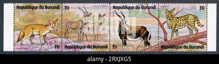 Streifen mit 4 Briefmarken mit afrikanischen Tieren. Burundi, 1975. Tiere: Vulpes zerda, Tragelaphus imberbis, Damaliscus pygargus phillipsi, Leptailurus serval Stockfoto