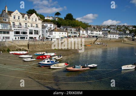Der St. Mawes Harbour mit dem Ship and Castle Hotel dahinter. Boote vor Anker am Strand und ein blauer Himmel. St Mawes, Cornwall, Großbritannien. Stockfoto