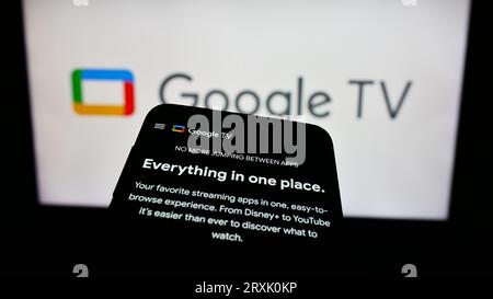 Mobiltelefon mit Video-on-Demand-Service Google TV auf dem Bildschirm vor dem Firmenlogo. Konzentrieren Sie sich auf die obere linke Ecke des Telefondisplays. Stockfoto