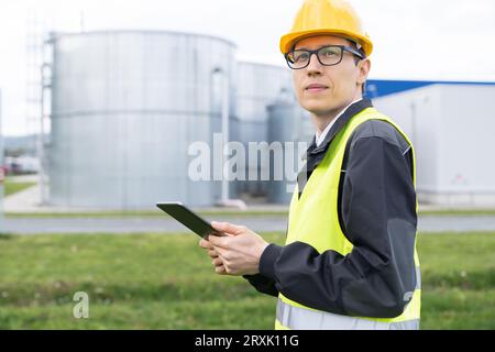 Ingenieur mit digitalem Tablet auf einem Hintergrund von Gastanks. Stockfoto