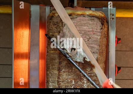 Küchenchef schneidet traditionellen türkischen Döner mit einem Döner-Messer Stockfoto