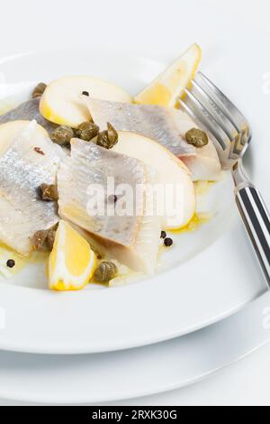 Hering, mariniert in Zitrone mit Apfel und Kapern in Leinöl. Stockfoto