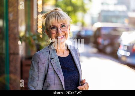 Porträt einer lächelnden Geschäftsfrau in der Stadt Stockfoto
