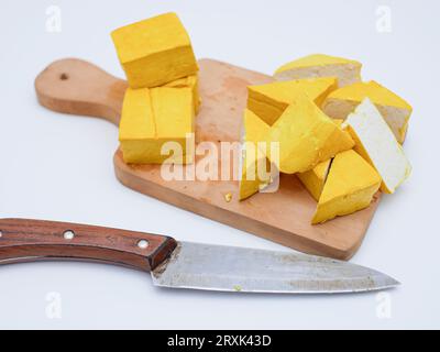 Roher gelber Tofu auf Holzschneidebrett Stockfoto