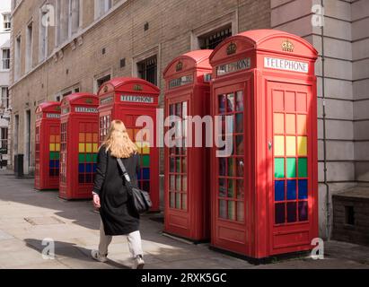 Eine Reihe klassischer K6-Telefonboxen in Rot, dekoriert mit LGBTQ-Regenbogenfarben in Broad Court, Covent Garden, London, England, Großbritannien Stockfoto