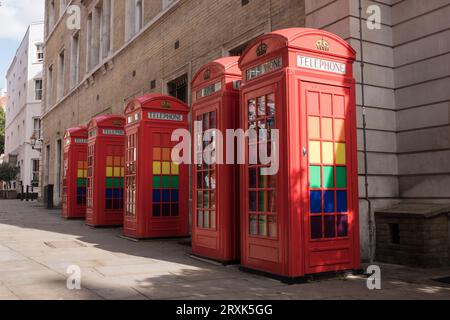 Eine Reihe klassischer K6-Telefonboxen in Rot, dekoriert mit LGBTQ-Regenbogenfarben in Broad Court, Covent Garden, London, England, Großbritannien Stockfoto