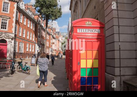 Eine Reihe klassischer K6-Telefonboxen in Rot, dekoriert mit LGBTQ-Regenbogenfarben in Broad Court, Covent Garden, London, England, Großbritannien Stockfoto