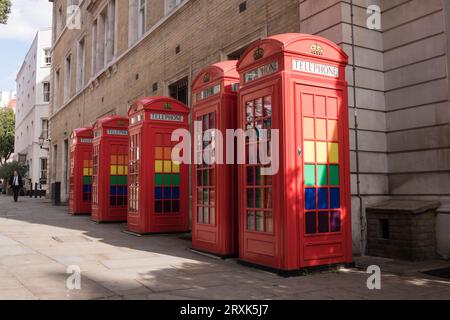 Eine Reihe klassischer K6-Telefonboxen in Rot, dekoriert mit LGBTQ-Regenbogenfarben in Broad Court, Covent Garden, London, England, Großbritannien Stockfoto