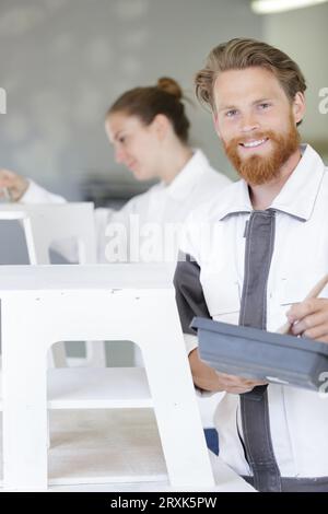 Mann, der einen Holzstuhl malt Stockfoto
