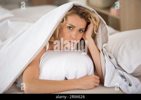 Verschlafene junge Frau, die sich nach dem Aufwachen schläfrig oder schwindelig fühlt Stockfoto