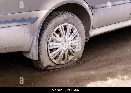 Nahaufnahme eines defekten Hinterrades eines Pkw-Fahrzeugs, das durch einen Nagel durchbohrt wurde. Selektiver Fokus. Pech, Unfallkonzept. Stockfoto