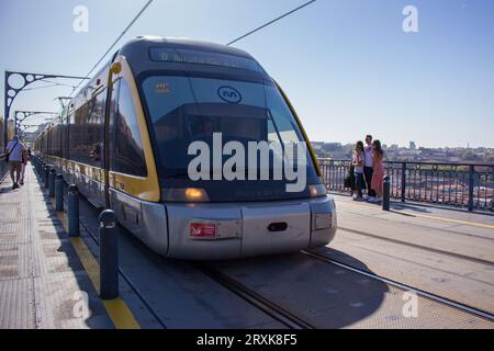 U-Bahn-Zug auf der berühmten Brücke über den Fluss Douro, Porto, Portugal. Konzept des öffentlichen Verkehrs. U-Bahn auf der Brücke in Porto. Das Stadtbild von Porto. Stockfoto