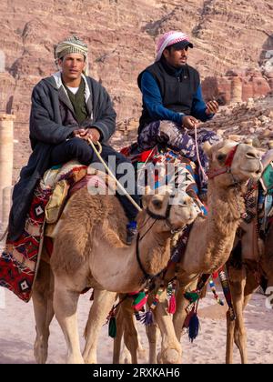 Die Einheimischen tragen Keffiyeh auf Kamelen in Petra, Jordanien Stockfoto