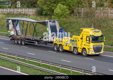 Zusammengestürzter, unfallbeschädigter, deformierter vorhanggebundener Anhänger, der von DibDale Autos als Rettungsdienst für schwere Lastkraftwagen am Straßenrand aufgefangen wird; auf der Autobahn M6 im Großraum Manchester, Großbritannien, mit hoher Geschwindigkeit unterwegs Stockfoto