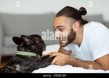 Mann, der morgens mit Hund im Bett spielt Stockfoto