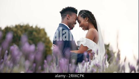Hochzeit, Braut und Bräutigam umarmen sich auf einem Feld, tanzen und feiern die Liebe mit Glück und Engagement. Ehe, Vertrauen und Schwarze Stockfoto