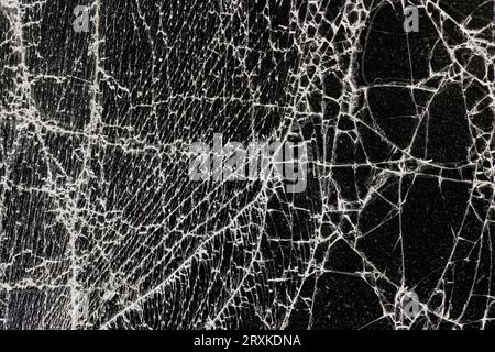 Verschmutztes Glas, das in eine große Anzahl von Teilen zerbrochen ist, ein Stück Glas mit vielen Rissen und gebrochenen Teilen Stockfoto